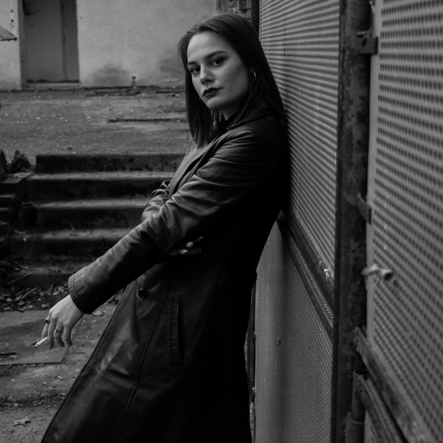 Žena u kaputu drži cigaretu